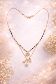 Gold necklace with black beads and pearls on a soft, blurred background